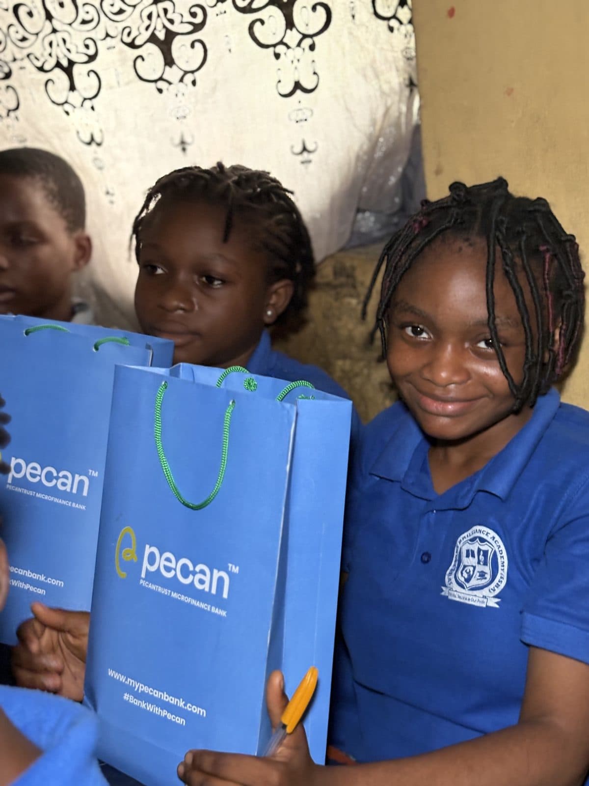 Schoolgirls in blue holding Pecan gift bags